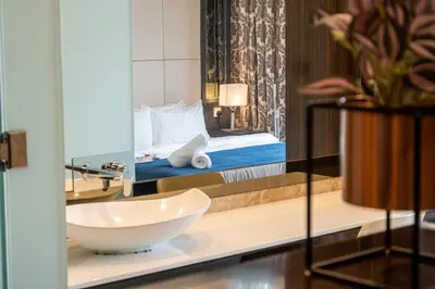 a bathroom with a sink and a bed and a mirror at Dorsett Residence Kuala Lumpur #21 in Kuala Lumpur