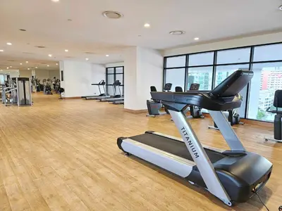 a gym with a treadmill and a row of treadmills at Cozy Fall Suite at EST Bangsar With Garden Scenery in Kuala Lumpur