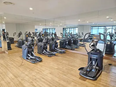 a gym with rows of treadmills and elliptical machines at Cozy Fall Suite at EST Bangsar With Garden Scenery in Kuala Lumpur