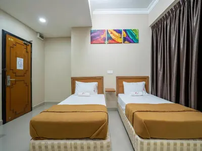 two beds sitting next to each other in a room at AGE Hotel in Kuala Lumpur