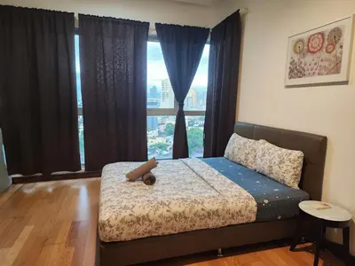 a bedroom with a bed and a large window at Regalia residence KLCC By Glory Homes in Kuala Lumpur