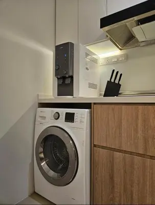 a kitchen with a washing machine and a microwave at Binjai 8 KLCC in Kuala Lumpur