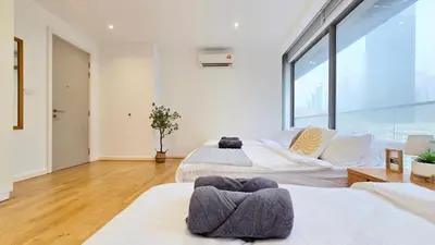 two beds in a room with a large window at Skyview Bukit Bintang Fairlane Residence #24 in Kuala Lumpur