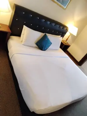 a large white bed with a blue pillow on it at KL Marigold Apartment At Times Square in Kuala Lumpur