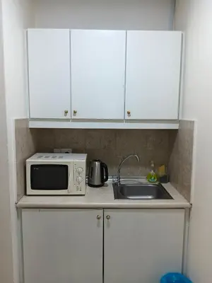 a kitchen counter with a microwave and a sink at KL Marigold Apartment At Times Square in Kuala Lumpur