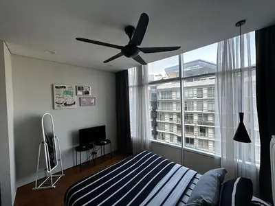 a bedroom with a ceiling fan and a large window at KLCC Private Bedroom in DUAL KEY Unit in Kuala Lumpur