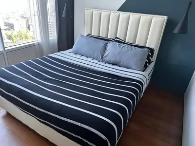 a bed with blue and white striped sheets and pillows at KLCC Private Bedroom in DUAL KEY Unit in Kuala Lumpur