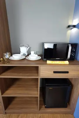 a microwave sitting on top of a wooden counter at The Adina - Bangsar Trade Centre in Kuala Lumpur