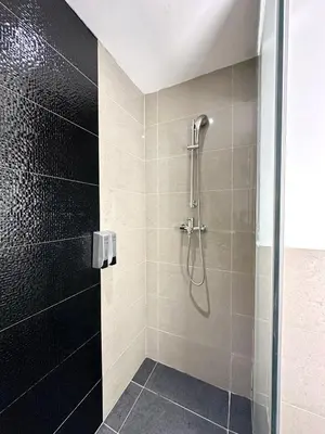 a bathroom with a shower with a glass door at The Teak - Bangsar Trade Centre in Kuala Lumpur