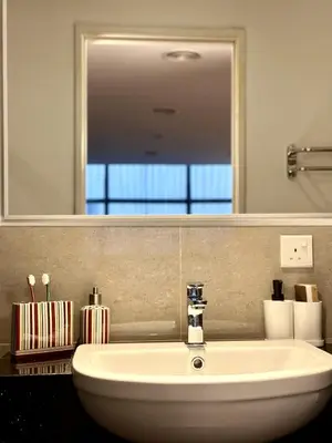 a bathroom with a sink and a mirror at The Teak - Bangsar Trade Centre in Kuala Lumpur