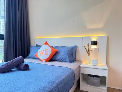 a bedroom with a bed with blue and orange pillows at The Trigo - Bangsar Trade Centre in Kuala Lumpur