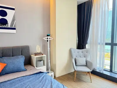 a bedroom with a bed and a chair and a window at The Trigo - Bangsar Trade Centre in Kuala Lumpur