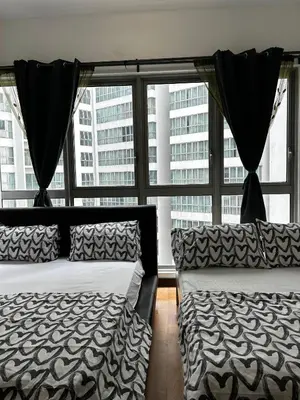two beds in a room with a large window at Stay at Regalia KLCC View Sky Pool in Kuala Lumpur