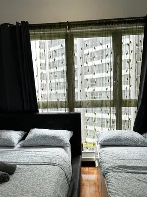 a bedroom with two beds and a window with blinds at Stay at Regalia KLCC View Sky Pool in Kuala Lumpur