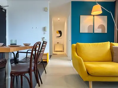 a living room with a yellow couch and a table at Arcoris Mont Kiara FaceHome in Kuala Lumpur