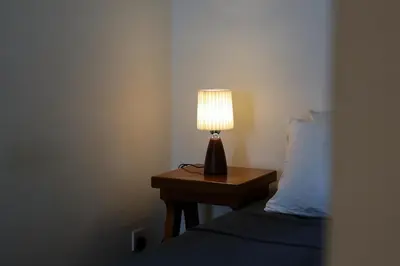 a lamp on a night stand next to a bed at Arcoris Mont Kiara FaceHome in Kuala Lumpur