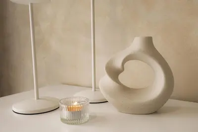 a white vase sitting on a table next to two candles at Agile Bukit Bintang in Kuala Lumpur