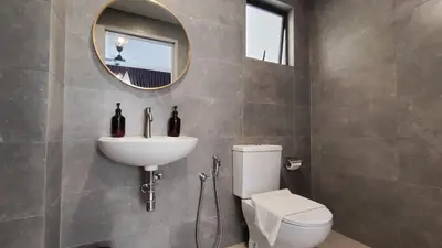 a bathroom with a toilet and a sink and a mirror at LSH33 Residence Sentul KL by HomeBrickz in Kuala Lumpur