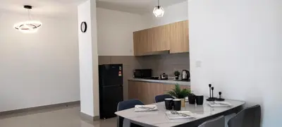 a kitchen with a table and chairs and a black refrigerator at LSH33 Residence Sentul KL by HomeBrickz in Kuala Lumpur
