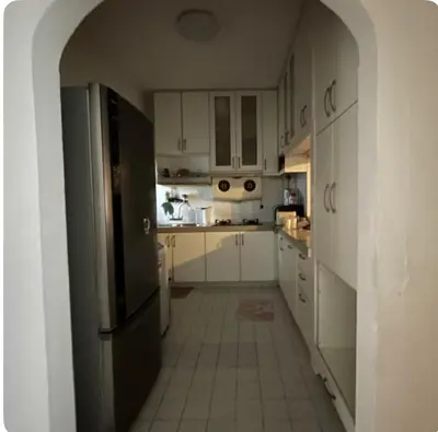 a kitchen with white cabinets and a black refrigerator at Condo in kuala lumpur in Kuala Lumpur