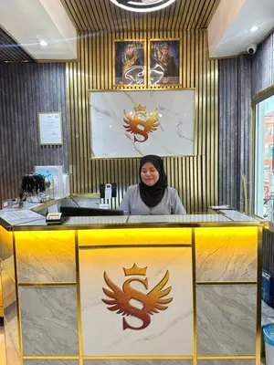 a woman sitting at a counter in a room with a banner at SS Grey inn Bukit Bintang in Kuala Lumpur