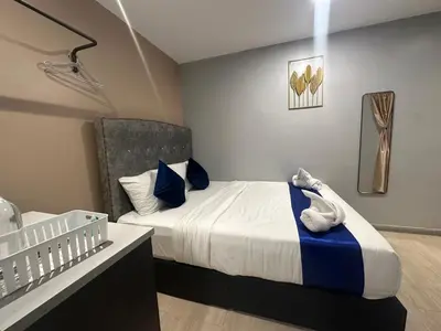 a bedroom with a bed with blue and white pillows at SS Grey inn Bukit Bintang in Kuala Lumpur