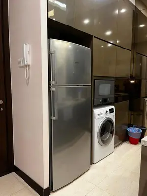 a refrigerator and a washing machine in a kitchen at Dorsett Residence Service Suites at Kuala Lumpur in Kuala Lumpur