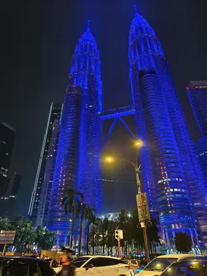 two tall buildings are lit up blue at night at Sky suites KLCC by Kuala Lumpur Family Room Stay in Kuala Lumpur