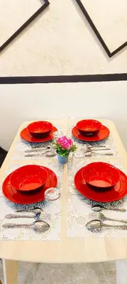 a table with red plates and spoons on it at Sky suites KLCC by Kuala Lumpur Family Room Stay in Kuala Lumpur