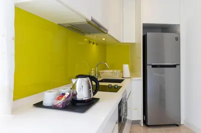 a kitchen with green walls and a refrigerator at The Signature Residence at Sri Hartamas - 2 pax in Kuala Lumpur