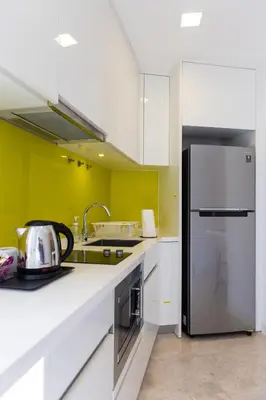 a kitchen with white cabinets and a stainless steel refrigerator at The Signature Residence at Sri Hartamas - 2 pax in Kuala Lumpur