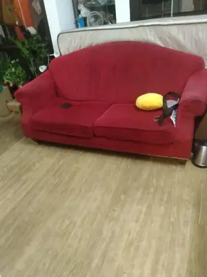a red couch with a yellow pillow on it at KL hotel time square in Kuala Lumpur