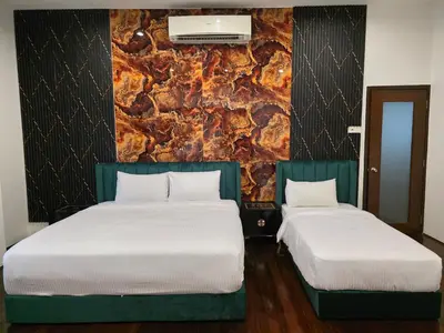 two beds sitting next to each other in a room at Bungalow Perkasa in Kuala Lumpur