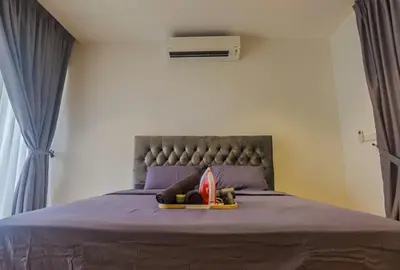 a bedroom with a bed with a headboard and shoes on it at Quill Luxe Stay - KLCC in Kuala Lumpur