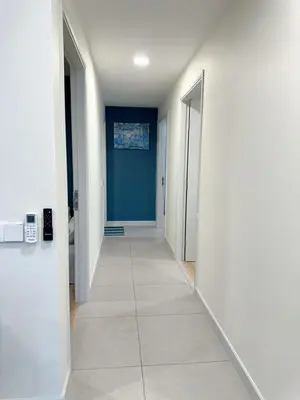 a hallway with white walls and a blue wall at The Atrium at Jalan Ampang by OKBnB - Luxury 3 Bedroom Family Suite with Balcony, 3 mins to KLCC in Kuala Lumpur