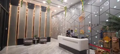a lobby with two people sitting at a counter at Royce Residences KLCC by WSD in Kuala Lumpur