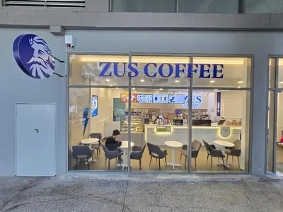 a man sitting at a table in a coffee shop at Kuala Lumpur Bintang Fairlane #157 TRX in Kuala Lumpur