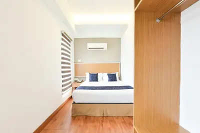 a bedroom with a bed with white sheets and blue pillows at Palette KL Sentral near Pudu LRT formerly RPC Blissful Homes in Kuala Lumpur