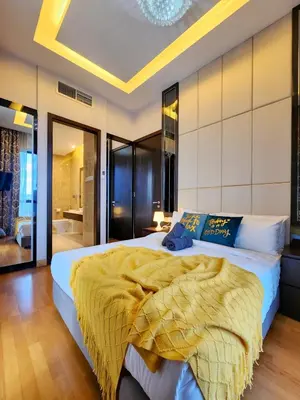 a bedroom with a large bed with a yellow blanket at Dorsett Residence Kuala Lumpur #08 TRX KLCC Pavilion in Kuala Lumpur