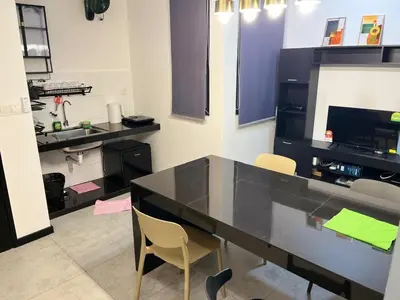 a kitchen with a black counter and two chairs at Neu Suites 2 Room Home Stay in Kuala Lumpur