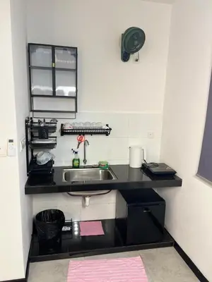 a kitchen with a sink and a black counter top at Neu Suites 2 Room Home Stay in Kuala Lumpur