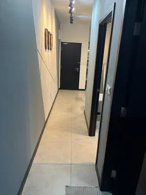 a hallway with a black door and a tile floor at Neu Suites 2 Room Home Stay in Kuala Lumpur