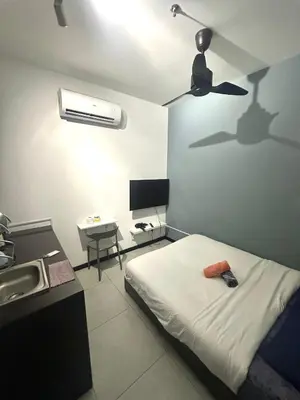 a bedroom with a bed and a sink and a ceiling fan at Neu Suites Studio Home Stay in Kuala Lumpur