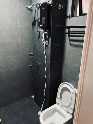 a bathroom with a toilet with a phone on the wall at Neu Suites 2 Bedroom Family Suites in Kuala Lumpur