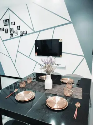 a black table with plates and a vase with flowers at Neu Suites 2 Bedroom Family Suites in Kuala Lumpur