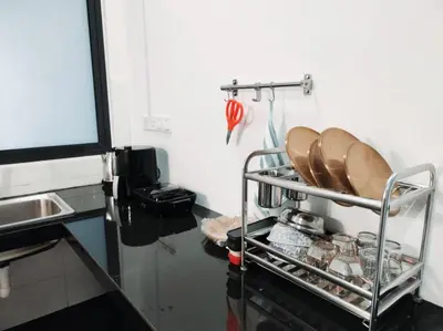 a kitchen with a metal rack with plates on it at Neu Suites 2 Bedroom Family Suites in Kuala Lumpur