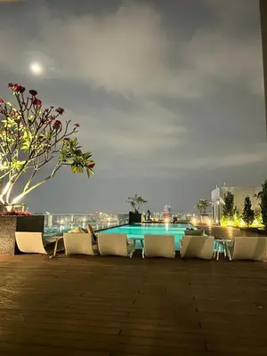 a group of chairs and a pool at night at Reveria city KL in Kuala Lumpur