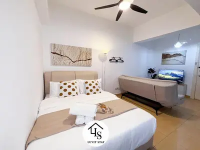 a bedroom with a bed and a couch and a television at Holiday Place by Luvit Stay in Kuala Lumpur