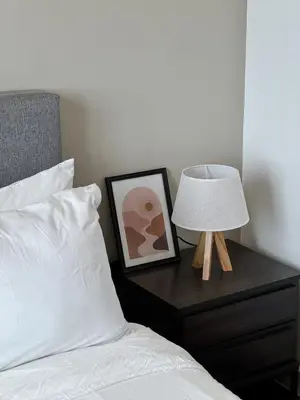 a bed with a lamp and a picture on a nightstand at DRapport APT got Bathtub & Kids Game by Iconique in Kuala Lumpur