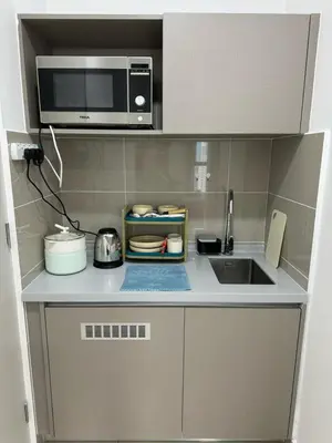 a small kitchen with a sink and a microwave at Trion KL By HomeTaric Suite in Kuala Lumpur